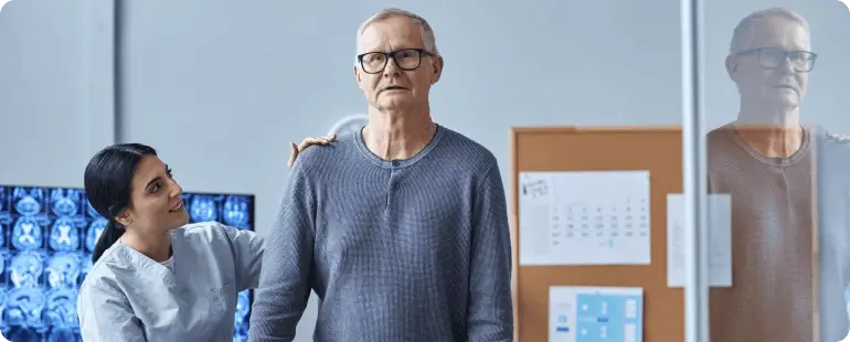 Physical therapist assisting an elderly man in a rehabilitation session