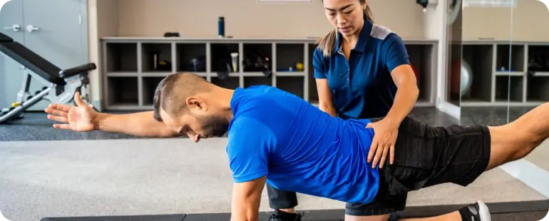 Therapist guiding patient through rehabilitation exercise during practical training in a clinical environment