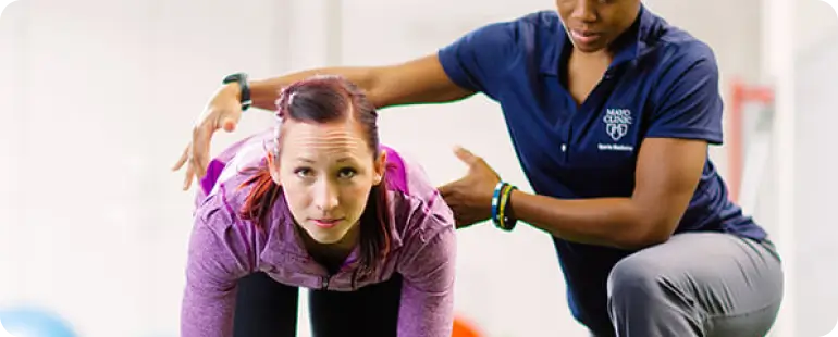 Certified therapist assisting athlete in SCS performance rehab routine