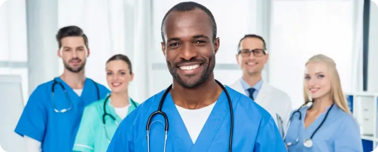 Smiling male agency nurse standing with healthcare professionals in hospital setting