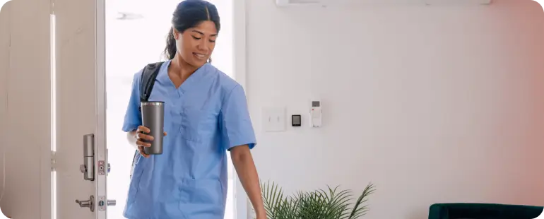 Female travel nurse entering her furnished apartment, representing the independence of housing stipends.