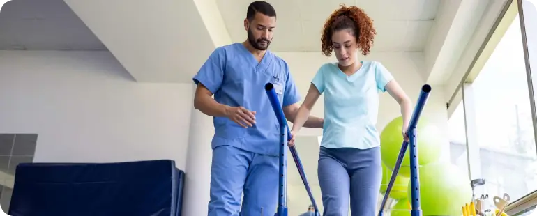 Physical therapist working with elderly patient using resistance band for muscle strengthening and recovery.