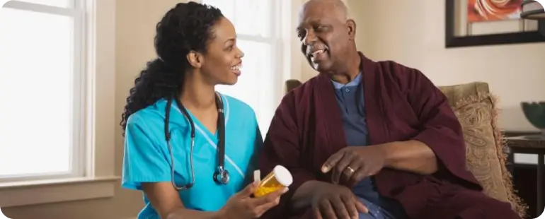 Long term care travel nurse assisting senior man with medication — compassionate care in LTC travel nurse roles.